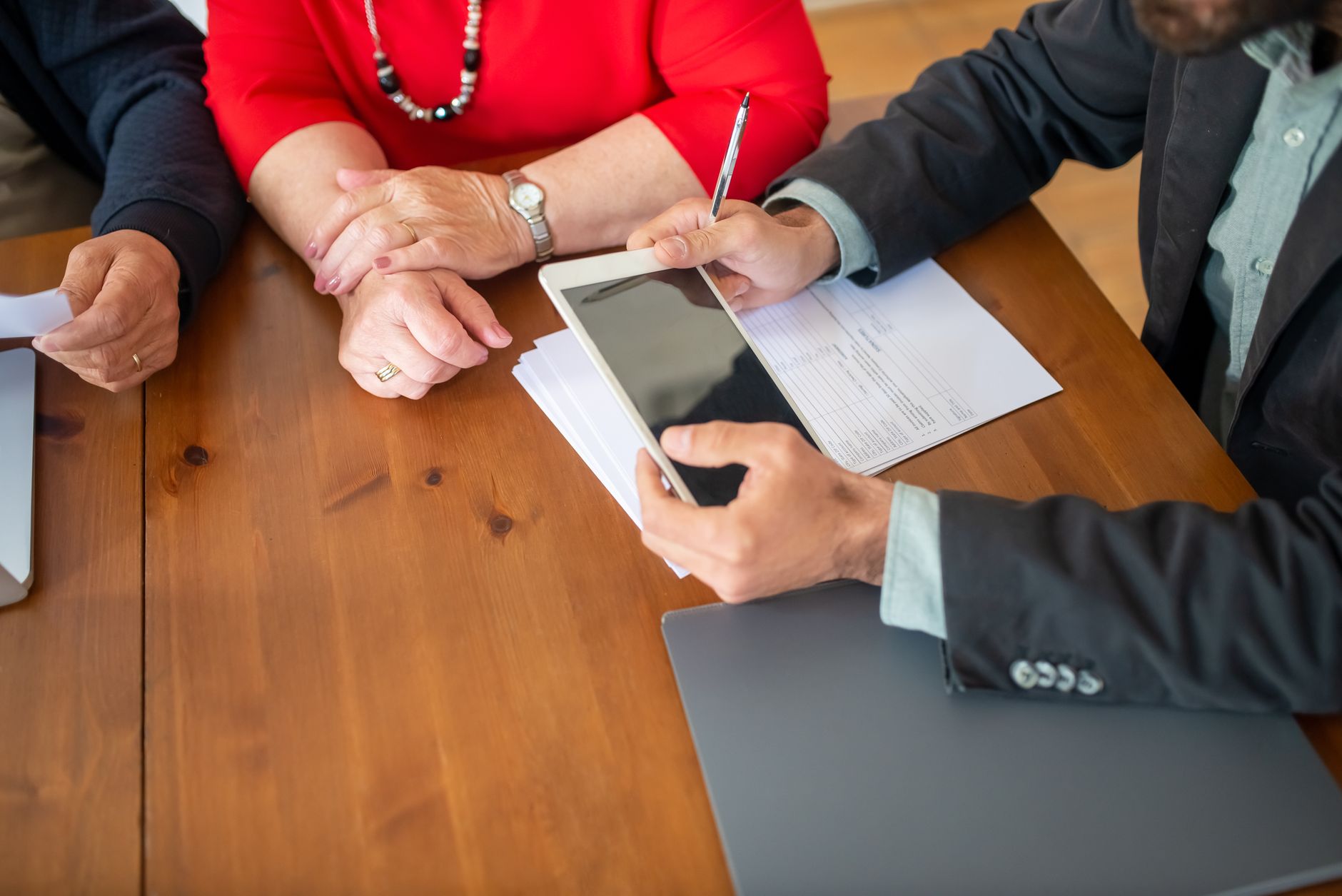 Adviesgesprek aan de keukentafel met tablet en berekening
